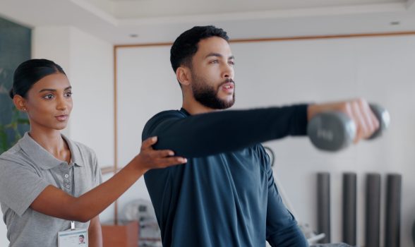 Help, man and woman in physiotherapy with dumbbell for fitness, muscle workout or exercise. Rehabil.